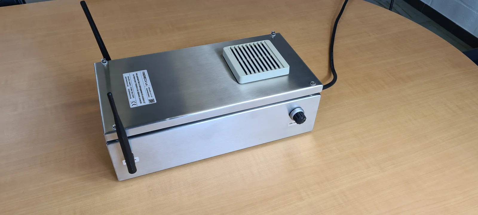Gateway LoRaWAN dans un coffret inox, deux antennes courtes montees a l'exterieur du couvercle.