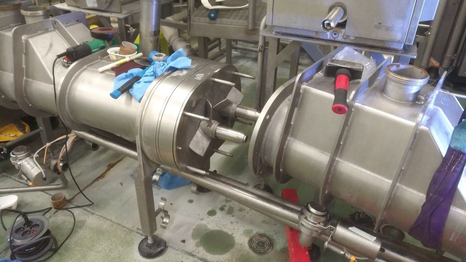 Machine de process en inox ouverte pour intervention, rotor et arbre dégagés, outils et gants posés sur le carter