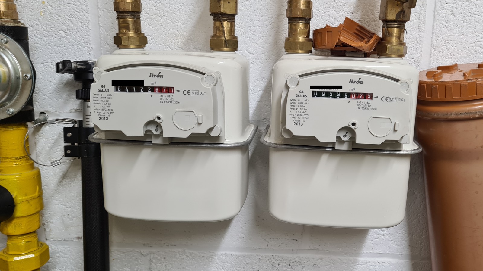 Deux compteurs de gaz installés côte à côte sur un mur technique