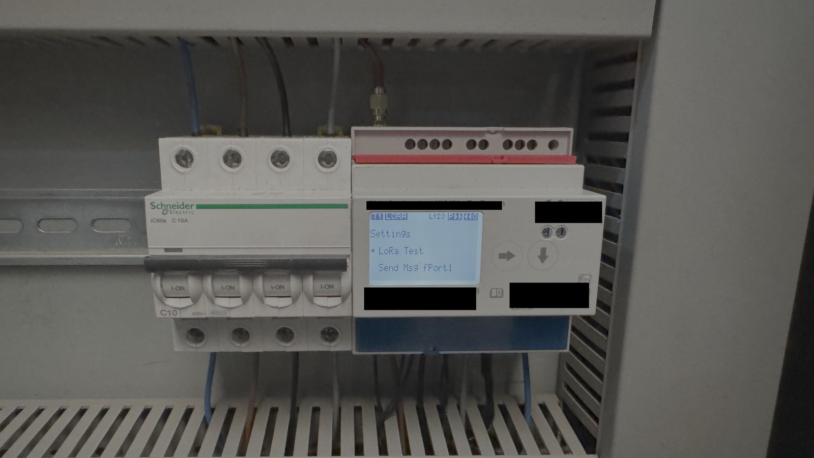 Coffret électrique avec disjoncteurs Schneider Electric et compteur d'énergie LoRaWAN affichant son menu de configuration